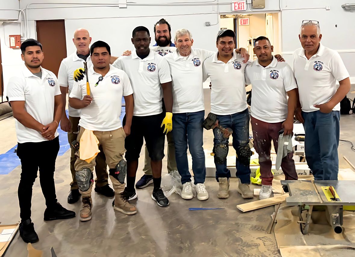 Mr. Does All New York renovation and remodeling team standing together in uniform inside a project site